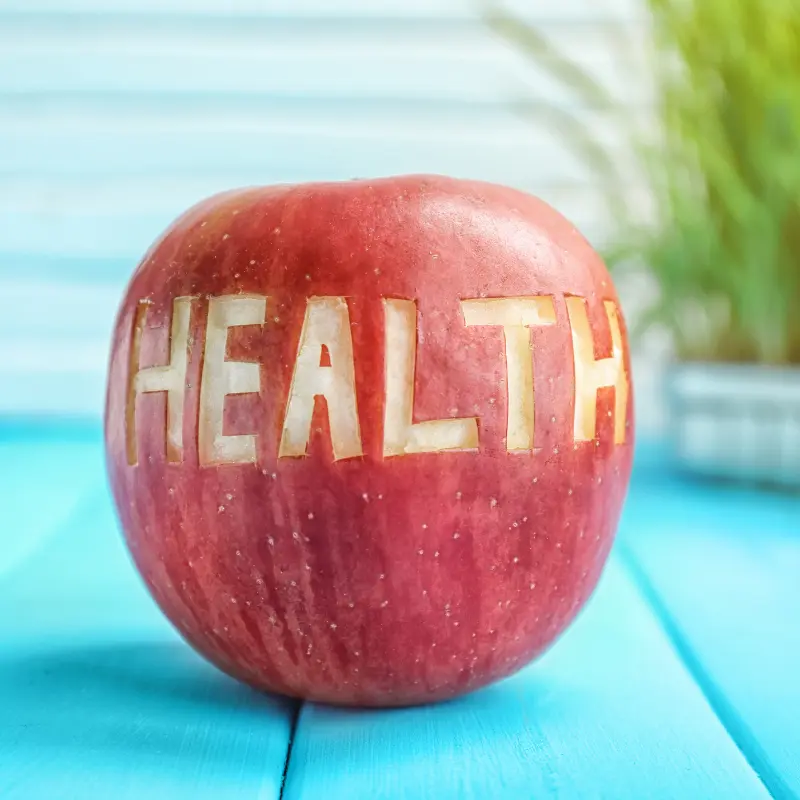 la_salud_se_copnstruye Imagen de una manzana con las letras salud en inglés hechas quitando parte de su piel. Indica la salud.